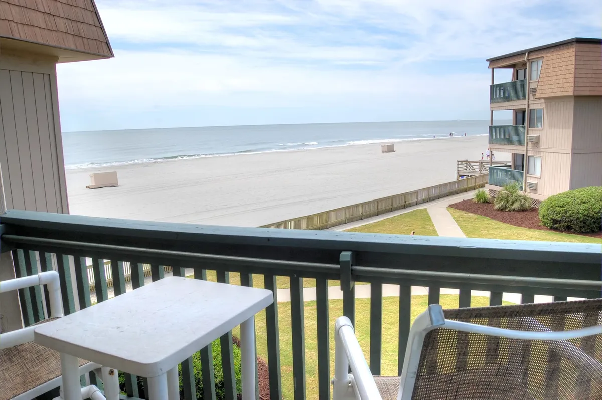 A tranquil view from the private balcony, with comfortable outdoor furniture facing a panoramic ocean vista. The scene invites residents to enjoy morning coffee or unwind with evening drinks as they watch the sunrise or sunset.